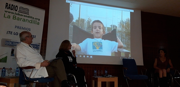 La presidenta de la Fundación También Teresa Silva durante la exposición del vídeo que ha presentado sobre el beneficio que aporta el deporte a las personas con discapacidad, ante la atenta mirada del Doctor Tomas Fernández, coordinador de esta jornada por parte de la Clínica CEMTRO y Mila López, Campeona de España de Ciclismo Adaptado.
